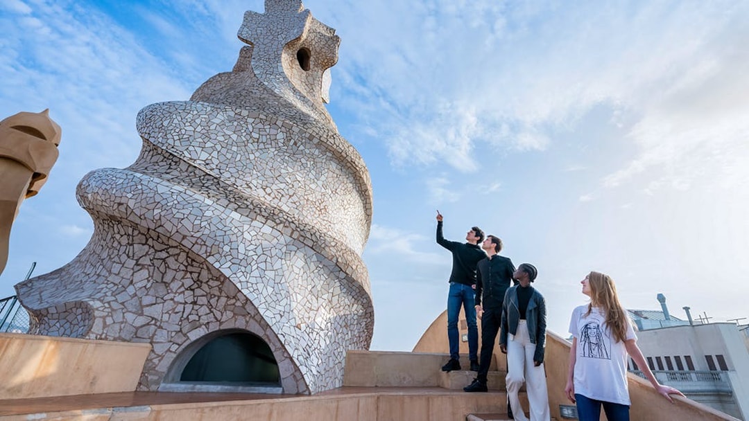 Visitors exploring the unique chimneys on La Pedrera-Casa Milà terrace in Barcelona.