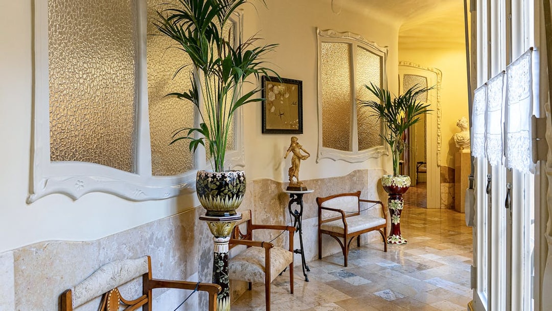 La Pedrera Casa Mila living room with ornate chairs and decorative plants.