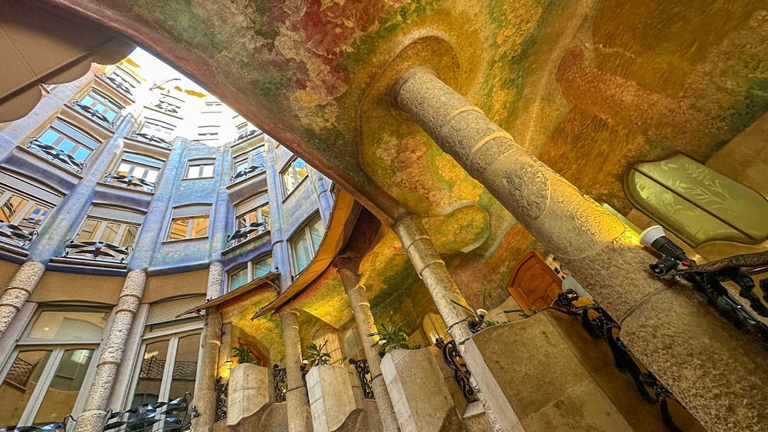 Casa Mila courtyard with colorful ceiling and spiral stair, Barcelona.