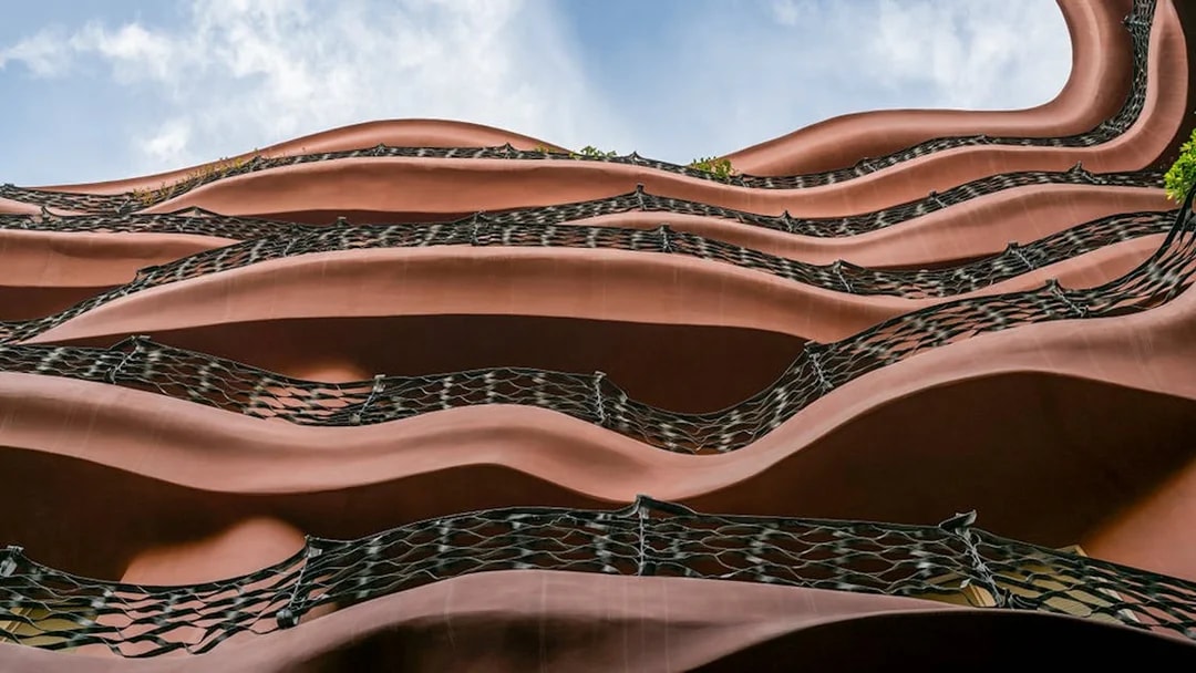 Wavy iron balconies of Casa Mila in Barcelona against a blue sky.