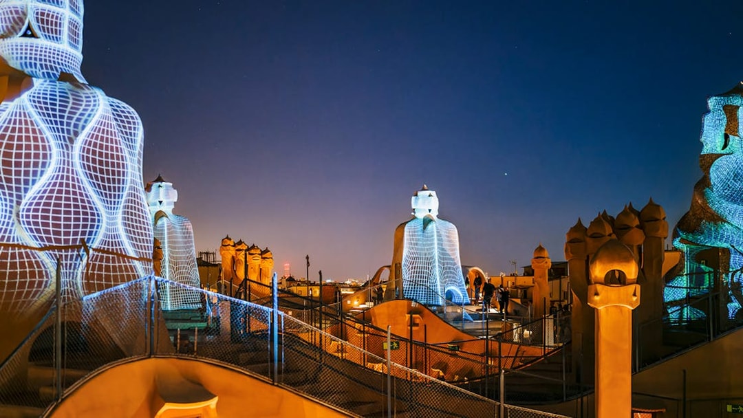 Casa Mila rooftop at night with illuminated chimneys during La Pedrera Night Experience in Barcelona.