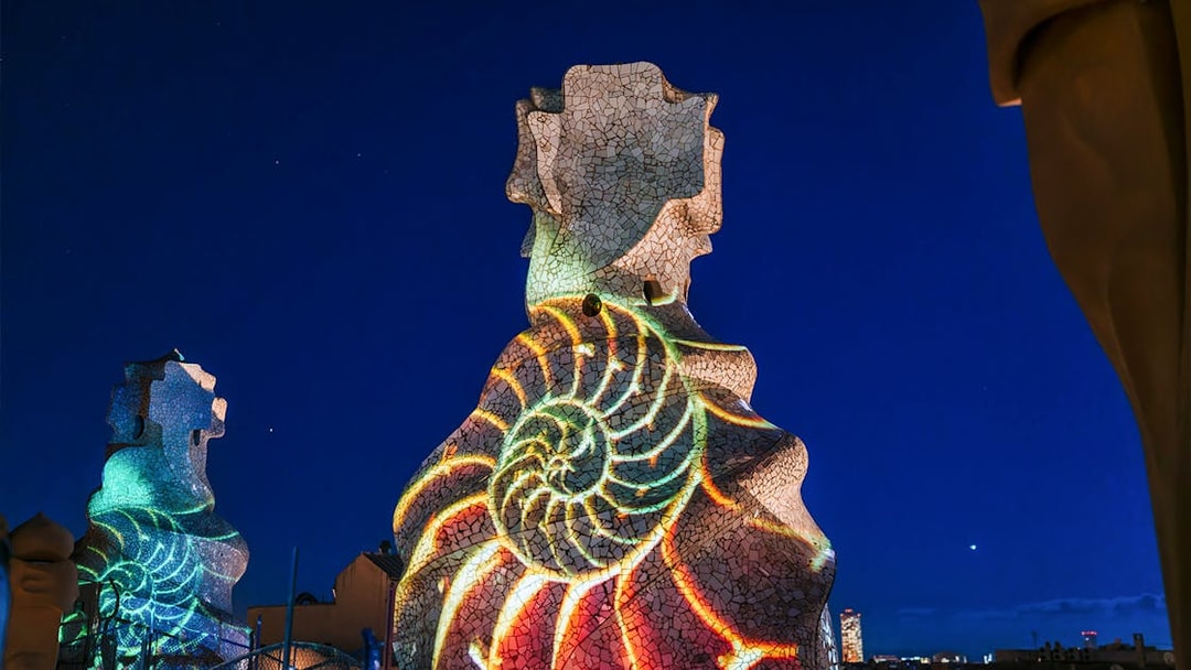 Light projection on Casa Mila chimneys during La Pedrera Night Experience in Barcelona.