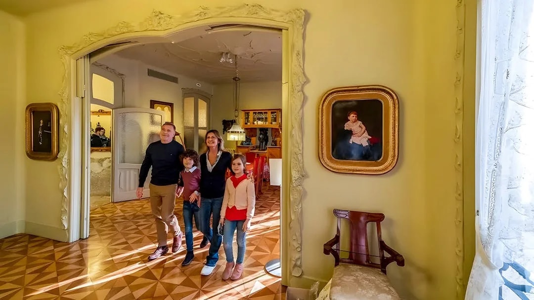 Family exploring interior of La Pedrera during guided tour in Barcelona.