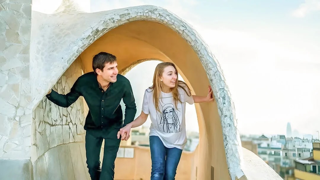 Couple exploring rooftop architecture on La Pedrera Fast Track Guided Tour in Barcelona.