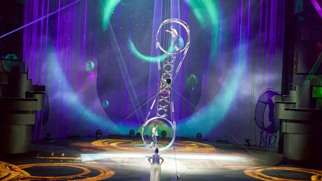 Acrobats performing at La Perle by Dragone in Dubai with vibrant stage lighting.