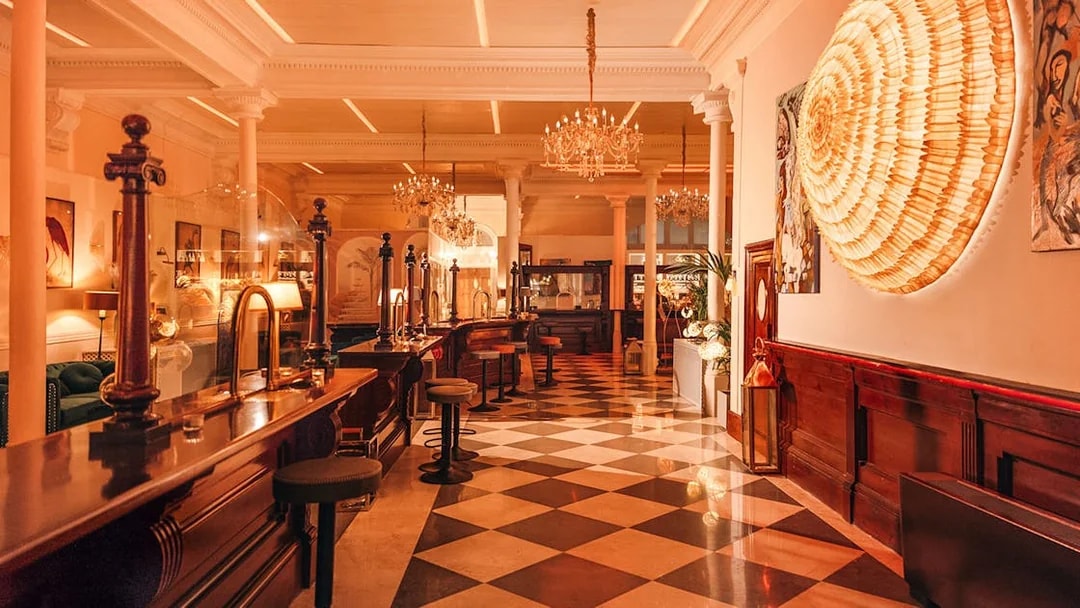 Elegant interior of a bar with chandeliers and checkered floor in Laietana, Barcelona.