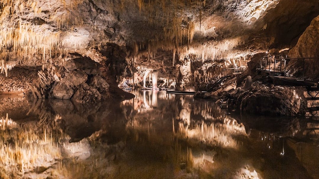 Stalactites reflected in still water inside Lake Cave, Margaret River.