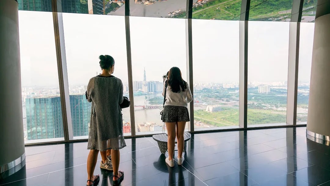 Visitors enjoying the panoramic view from a sky deck in downtown Ho Chi Minh City, Vietnam.