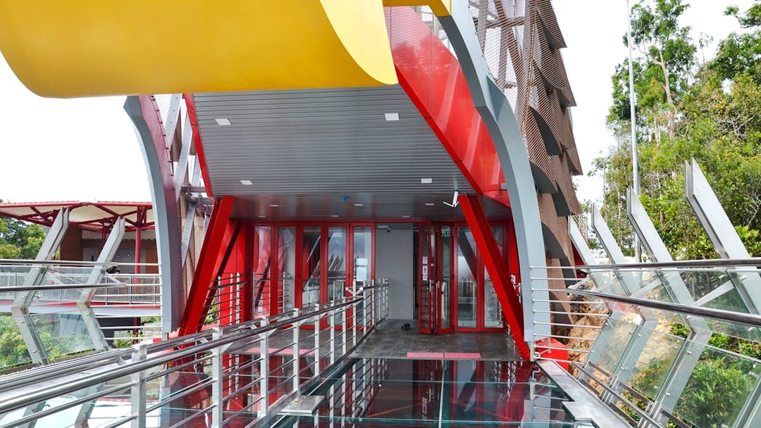 Langkawi Skywalk entrance with glass floor and red steel beams.
