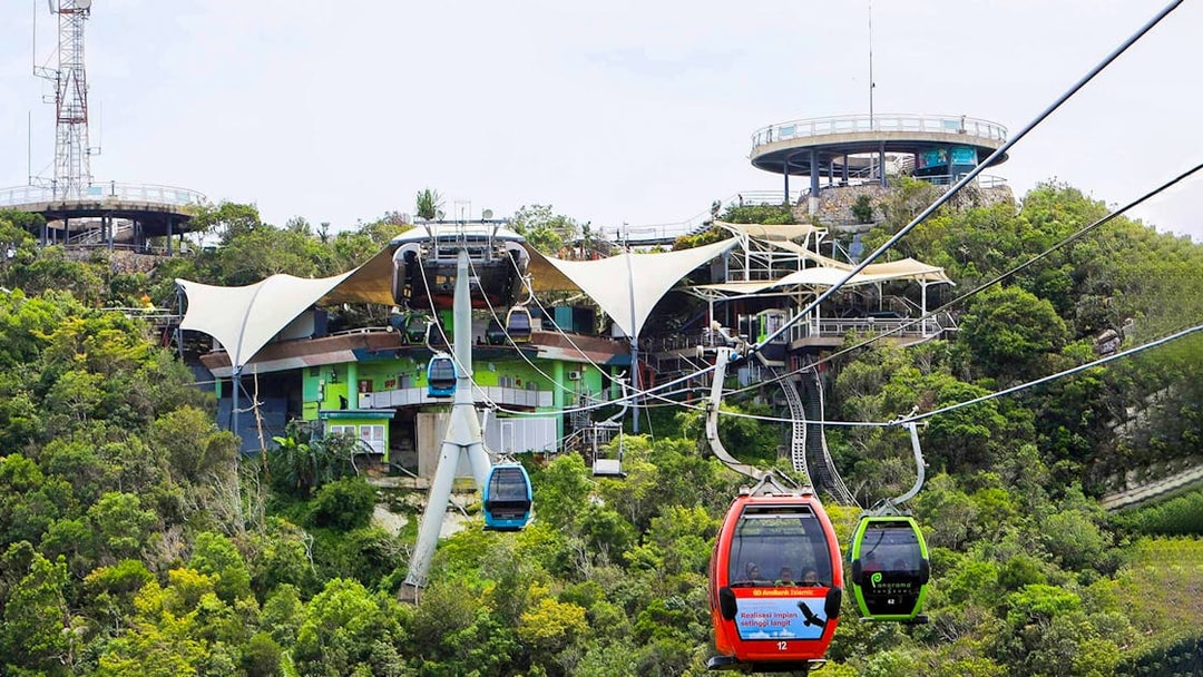 SkyCab cable cars ascending over lush greenery in Langkawi, Malaysia.