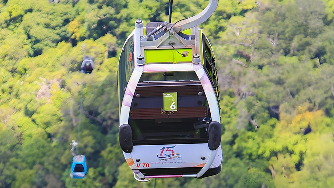 Glass bottom cable car over lush forest during Langkawi cable car tour.