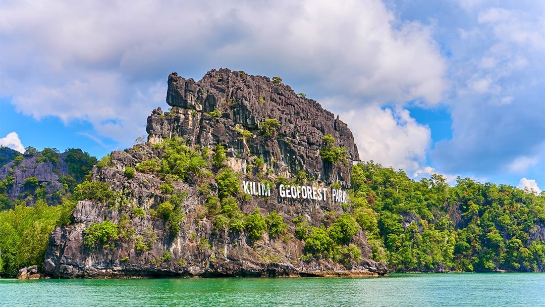 Kilim Geoforest Park sign on rocky hill, Langkawi, Malaysia.
