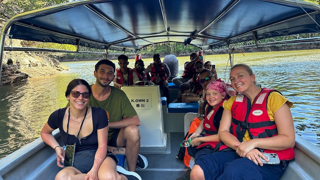 Passengers in life vests on a boat during Langkawi mangrove tour.