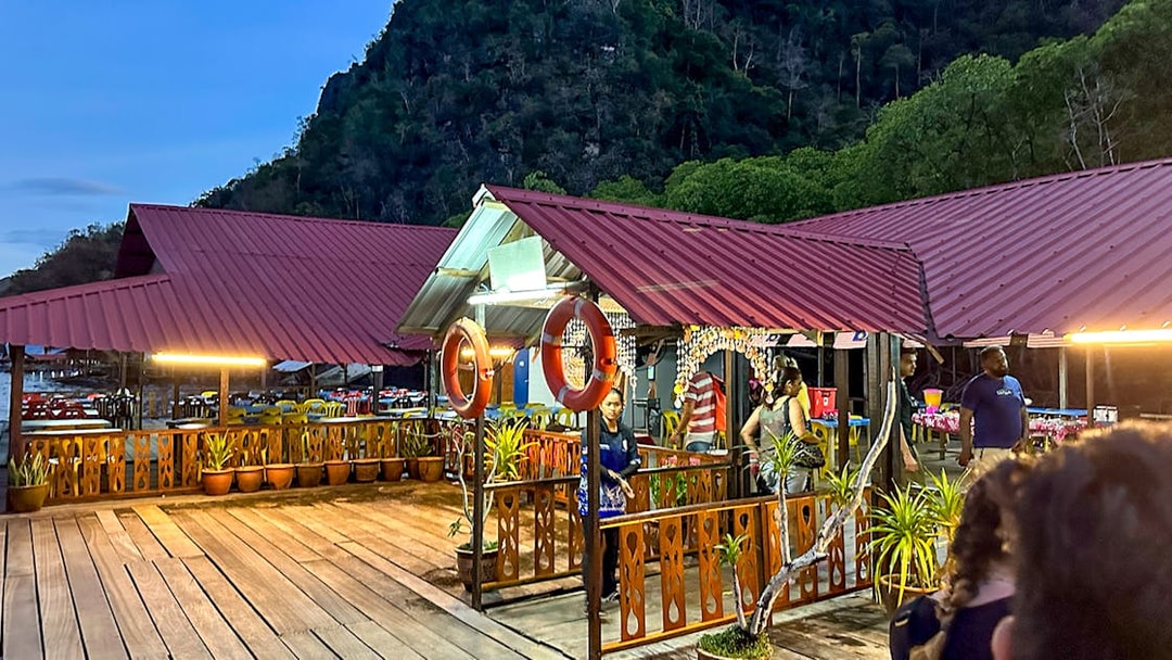Floating restaurant platform illuminated at dusk during Langkawi night mangrove tour.