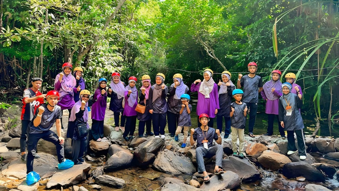 Group of people in helmets posing on rocks during Langkawi Sky ATV Ride at Mountain Manchinchang.