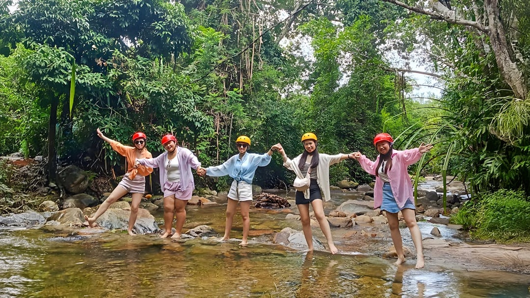 Group enjoying Langkawi Sky ATV Ride at Mountain Manchinchang, standing in a forest stream.