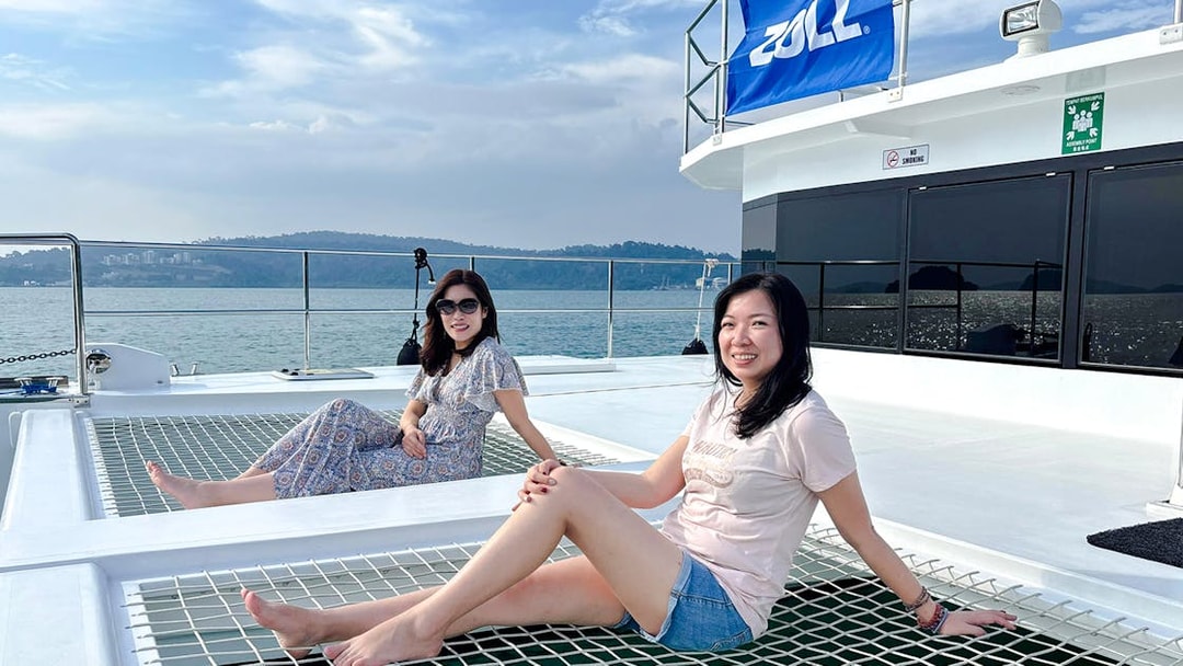 Women relaxing on a jacuzzi net during Langkawi sunset cruise.
