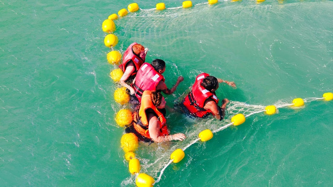 People enjoying water activities in life jackets during Langkawi sunset cruise.