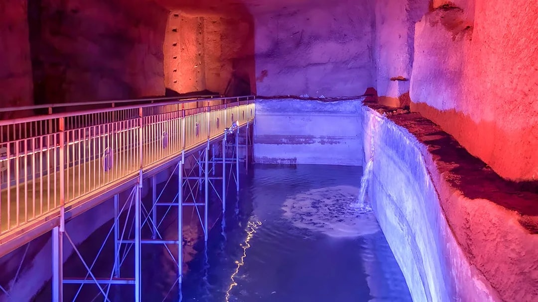 Underground walkway with colorful lighting at LAPIS Museum, Naples.