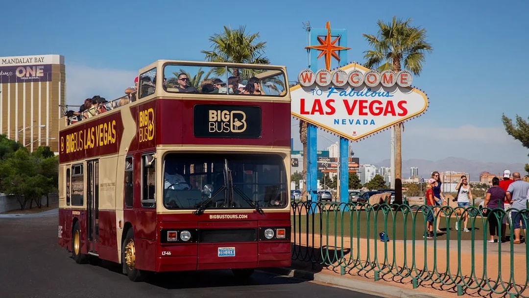 Open-top tour bus near the Welcome to Las Vegas sign, Nevada.