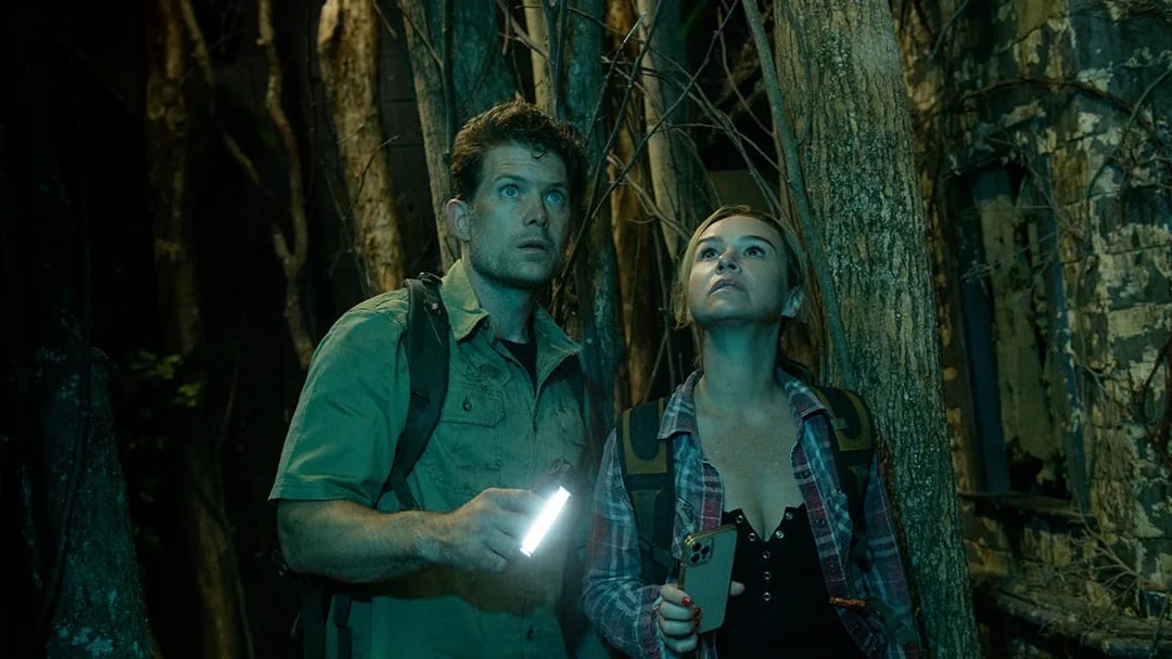 Couple exploring a dark forest with flashlights, part of Go City: Las Vegas Explorer tour.