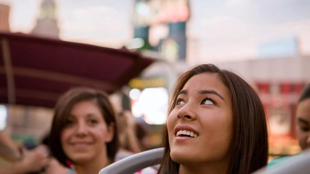 Tourists enjoying a bus tour in Las Vegas with cityscape in the background.