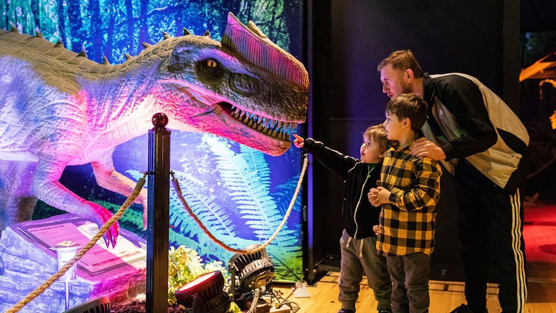 Family exploring dinosaur exhibit at Las Vegas attraction.