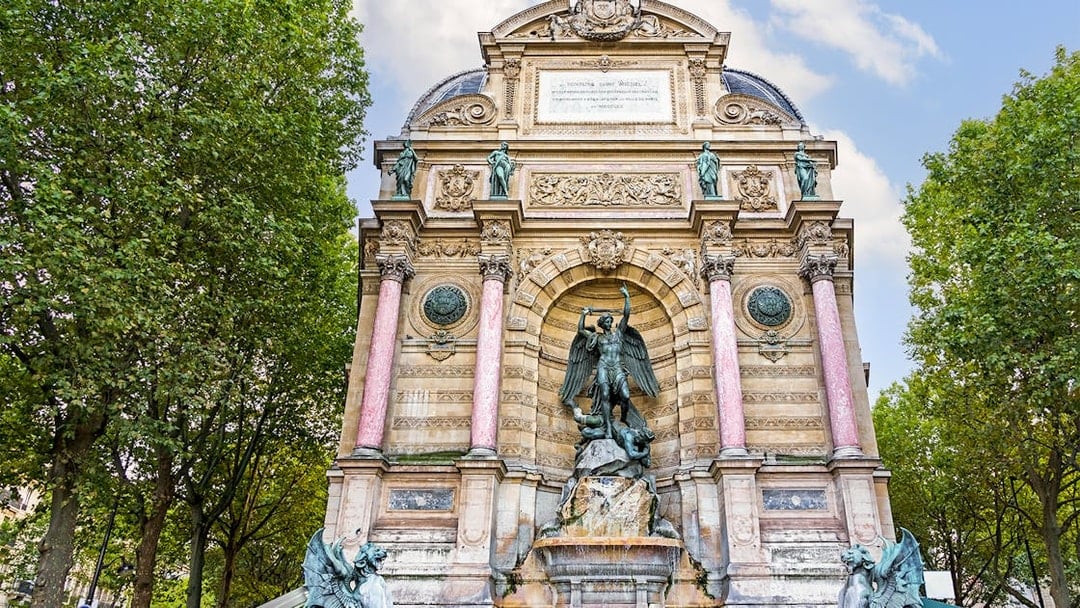 Saint-Michel Fountain in Paris' Latin Quarter with ornate sculptures and columns.