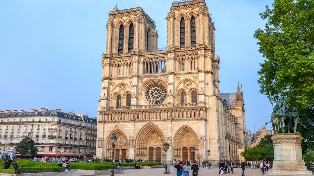 Notre Dame de Paris Cathedral facade with visitors in the foreground, France.