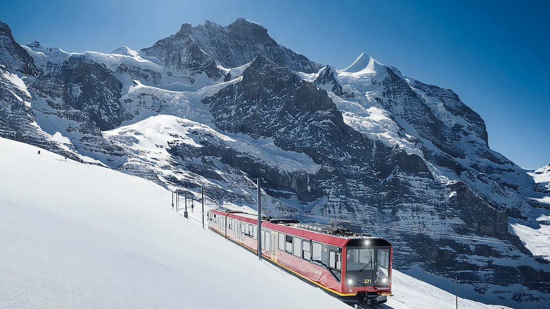 Jungfraubahn train ascending snowy Alps towards Jungfraujoch, Switzerland.