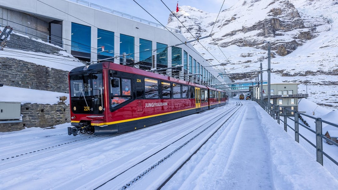 Jungfraubahn train arriving at snowy Jungfraujoch station, Switzerland.