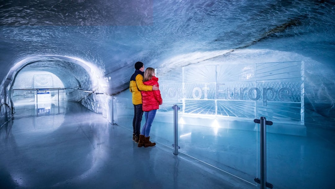Couple exploring ice tunnel at Jungfraujoch, Switzerland.