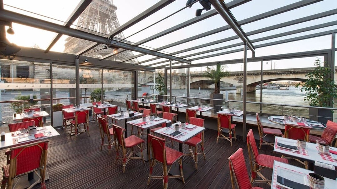 Le Bistro Parisien dining area with Eiffel Tower view, near Seine River, Paris.