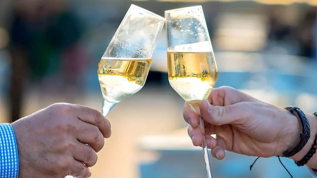Toasting champagne glasses on Le Diamant Bleu Seine River cruise.