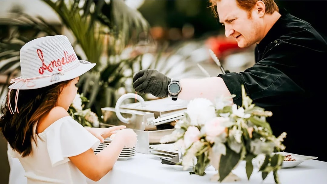 Chef serving food to a child on the Le Diamant Bleu Seine River cruise buffet.