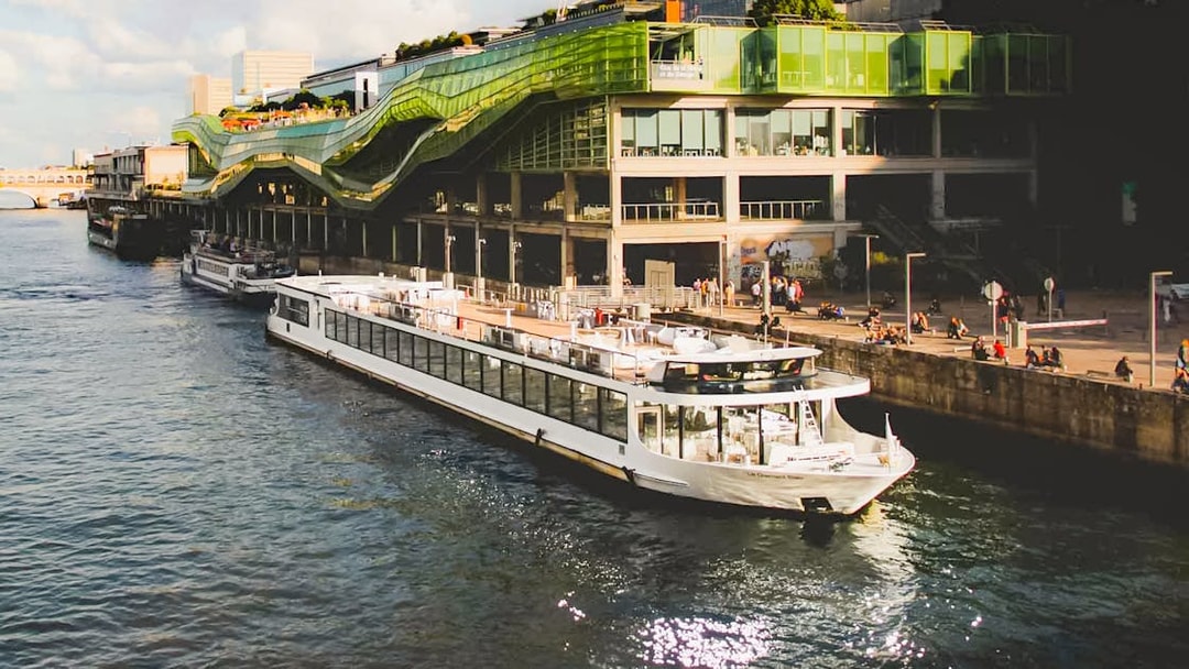 Diamant Bleu cruise ship docked by a modern building in Paris.