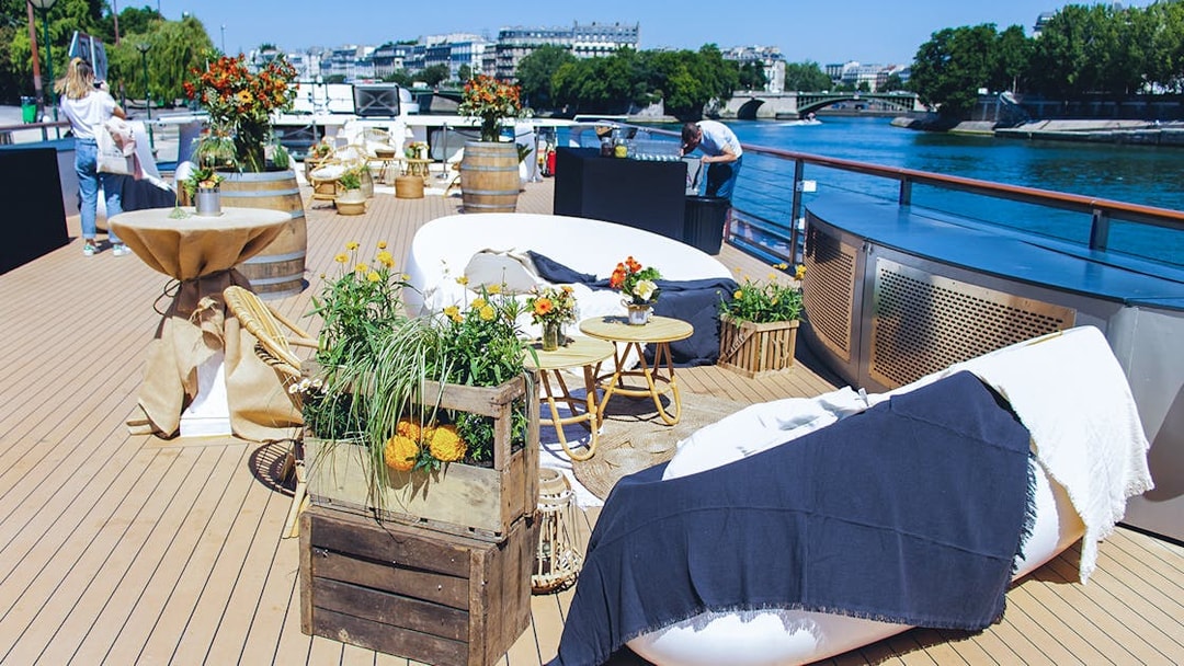Seine River cruise deck with seating and floral decor for Le Diamant Bleu dinner experience.
