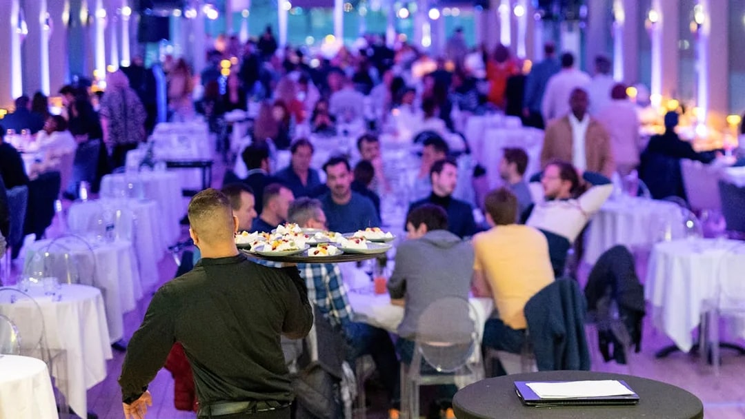Server carrying dishes during Le Diamant Bleu Seine River dinner cruise in Paris.