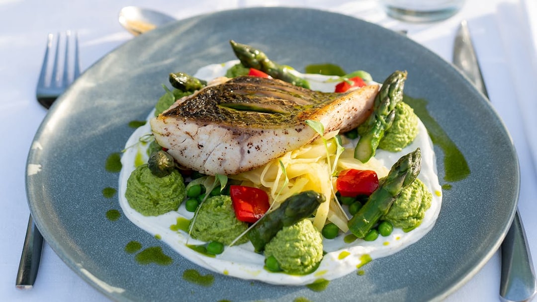 Grilled fish with asparagus and vegetables on Le Diamant Bleu Seine River dinner cruise.