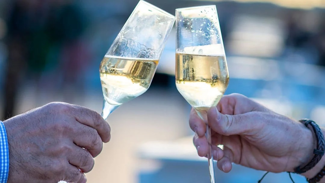 Toasting champagne glasses on Le Diamant Bleu Seine River dinner cruise.