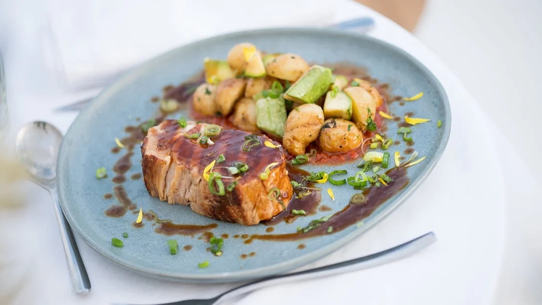 Seared meat with sauce and vegetables on a plate, served on Le Diamant Bleu Seine River cruise.