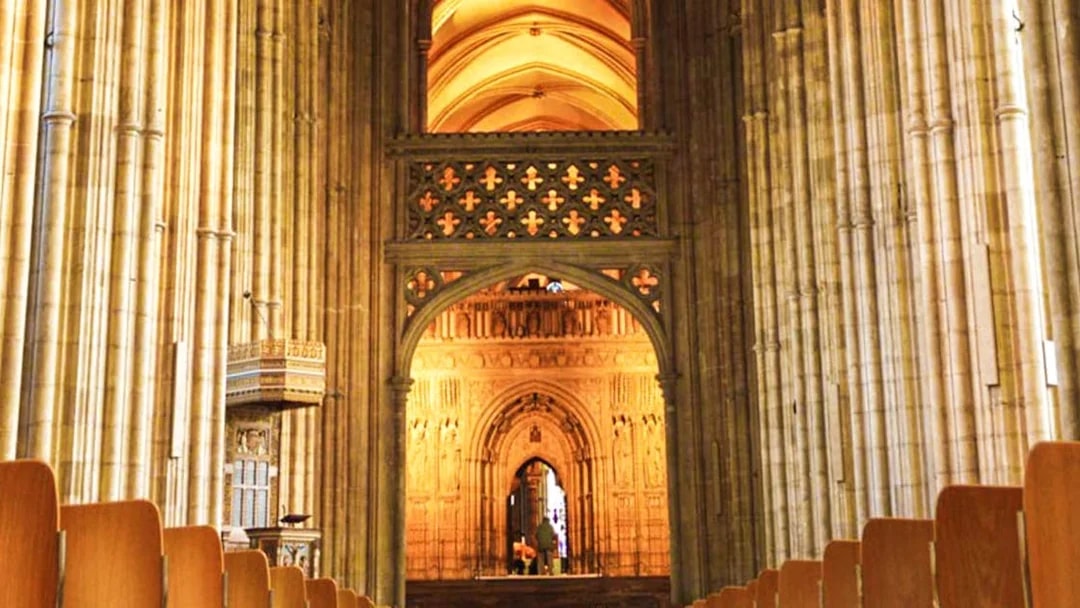 Interior view of Canterbury Cathedral's nave with ornate arches and columns.