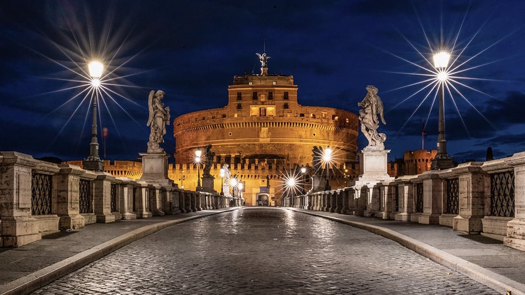 Castel Sant'Angelo illuminated at night with statues on the bridge, Rome, Italy.
