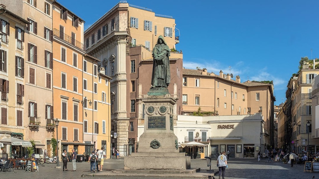 Statue of Giordano Bruno in Campo de Fiori, Rome, surrounded by historic buildings.