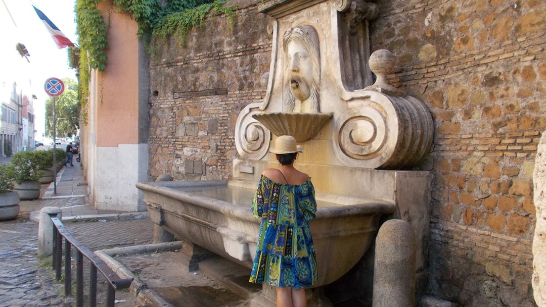 Woman standing at the Fontana della Boccaccia in Rome, Italy.
