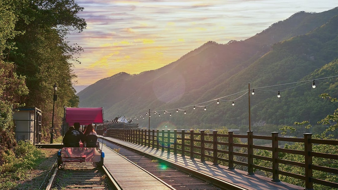 Couple riding Gangchon Railbike at sunset with mountain view in Korea.