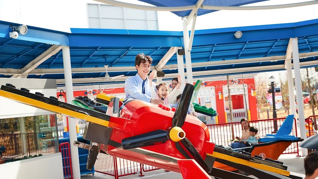 Family enjoying a colorful airplane ride at Legoland Korea.