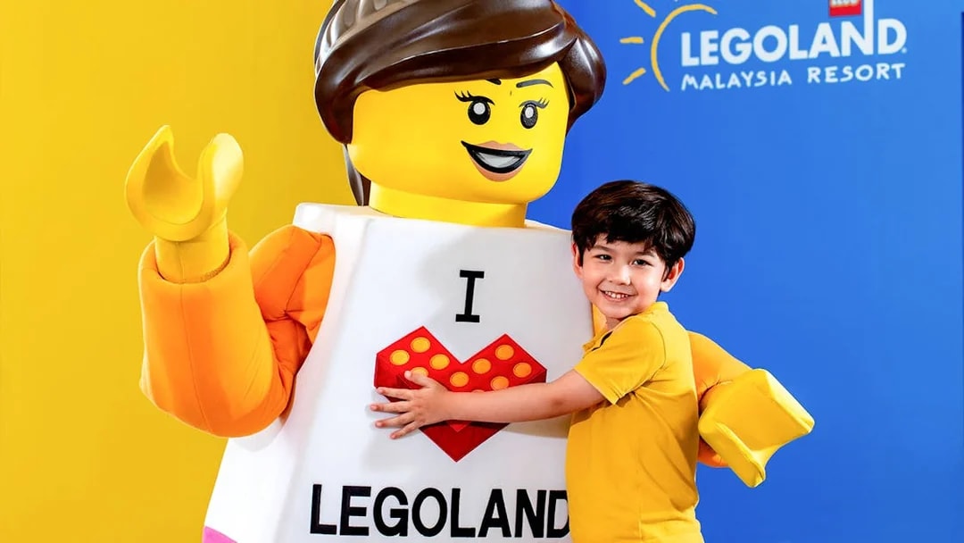 Child embracing LEGO character at Legoland Malaysia Resort.