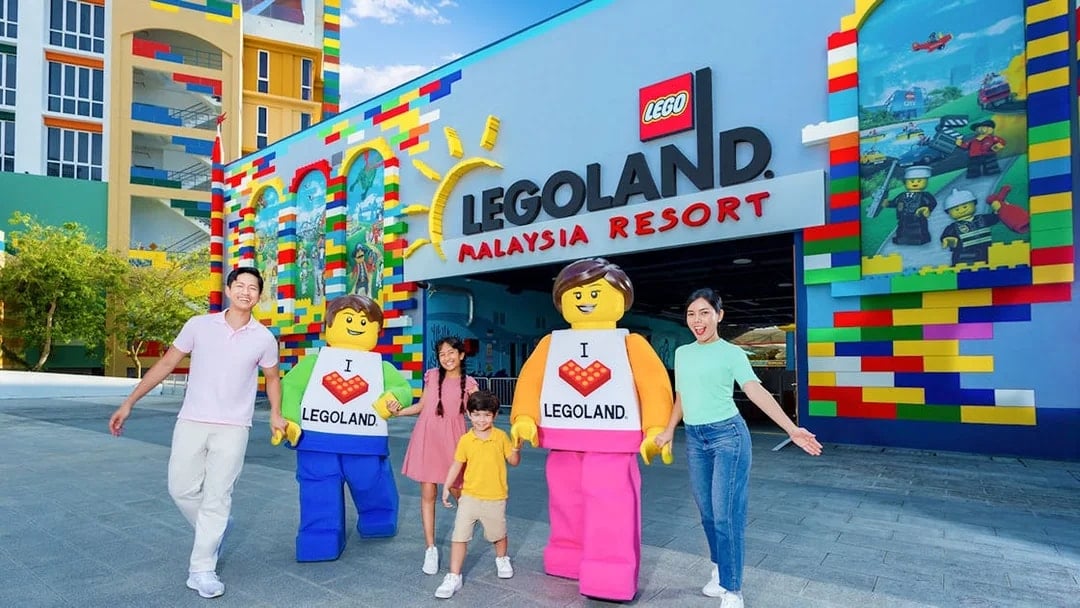 Family with LEGO characters at Legoland Malaysia Resort entrance.