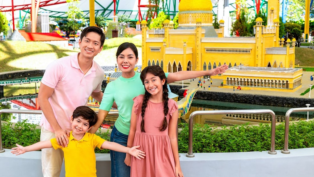 Family posing with LEGO model of Petronas Towers at Legoland Malaysia's Miniland.